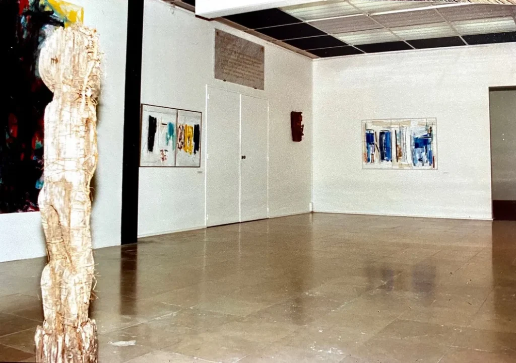 Sculpture Asmat regardant les toiles de Jean-Marc Vallin